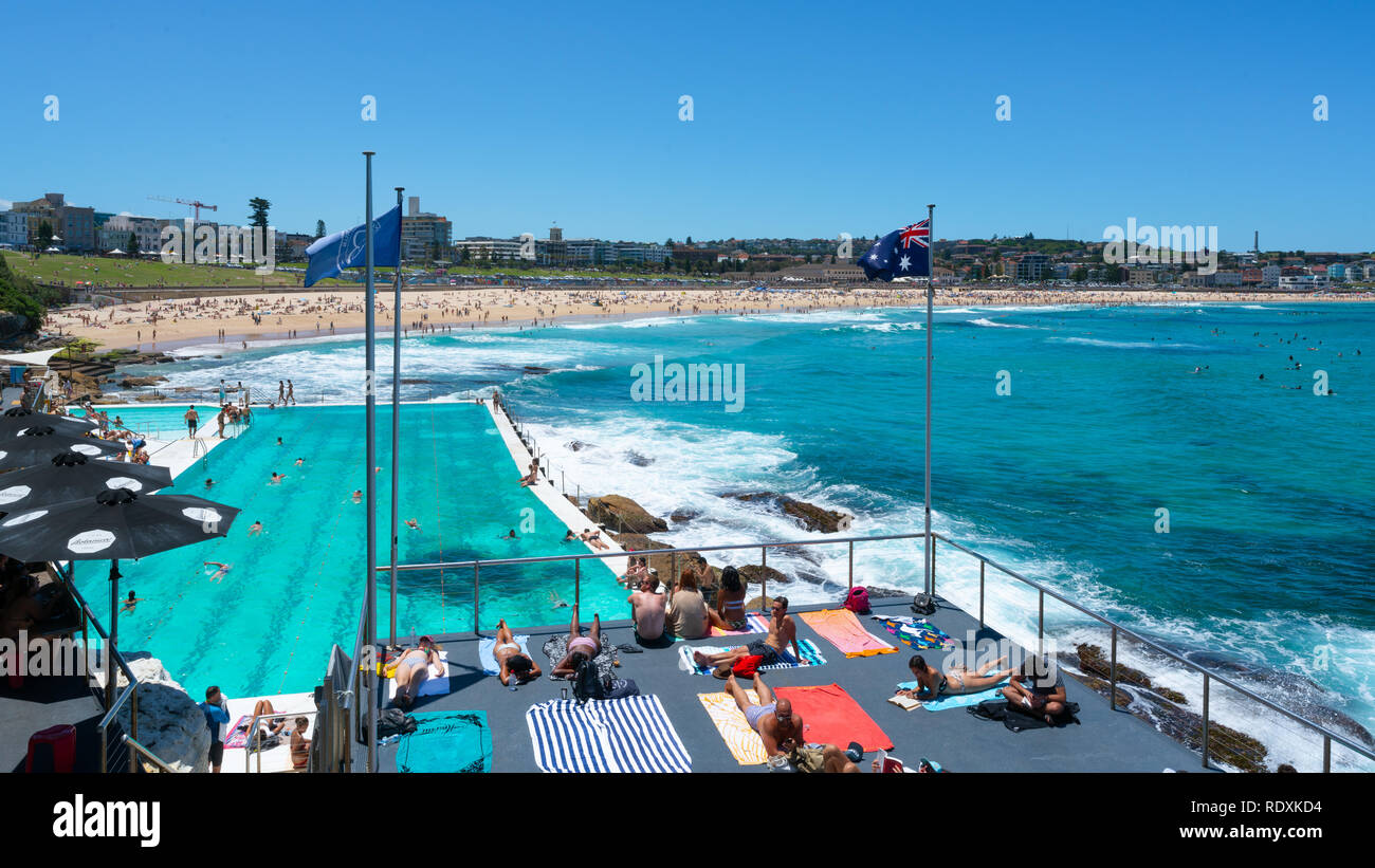 24 décembre 2018, l'Australie Sydney Bondi : piscine et drapeau australien en face de Bondi Beach panorama avec les gens de soleil sous le soleil d'été Banque D'Images