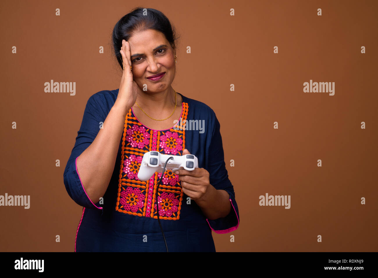 Femme indienne à jouer à des jeux vidéo en utilisant un contrôleur de jeu Banque D'Images Femme indienne à jouer à des jeux vidéo en utilisant un contrôleur de jeu Banque D'Images