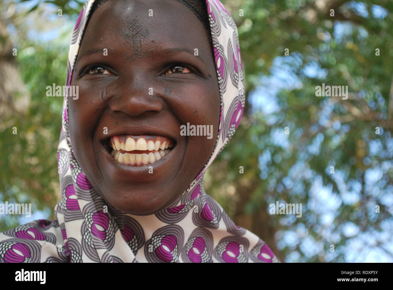 Une jeune femme Peul au Niger, Afrique, capturé par l'appareil photo tout en partageant l'humour avec un ami. Banque D'Images