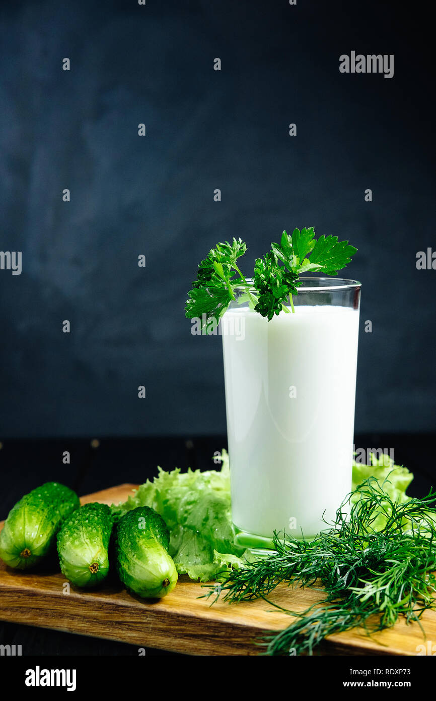 Plaine des yaourts frais avec les herbes de concombre sur fond sombre, froid boisson probiotique laitiers fermentés. Banque D'Images