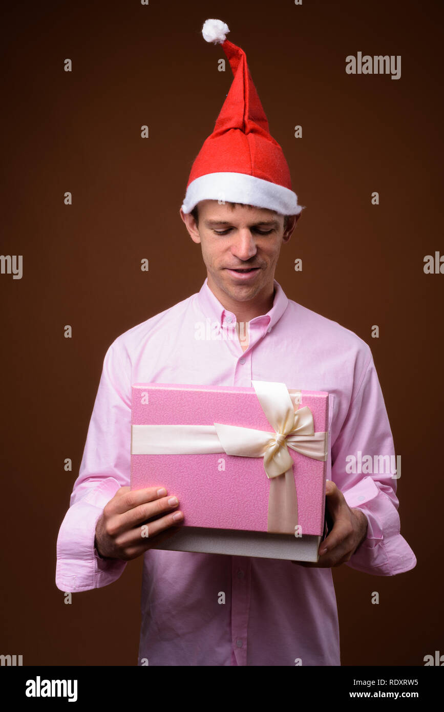 Businessman prêt pour Noël contre fond brun Banque D'Images