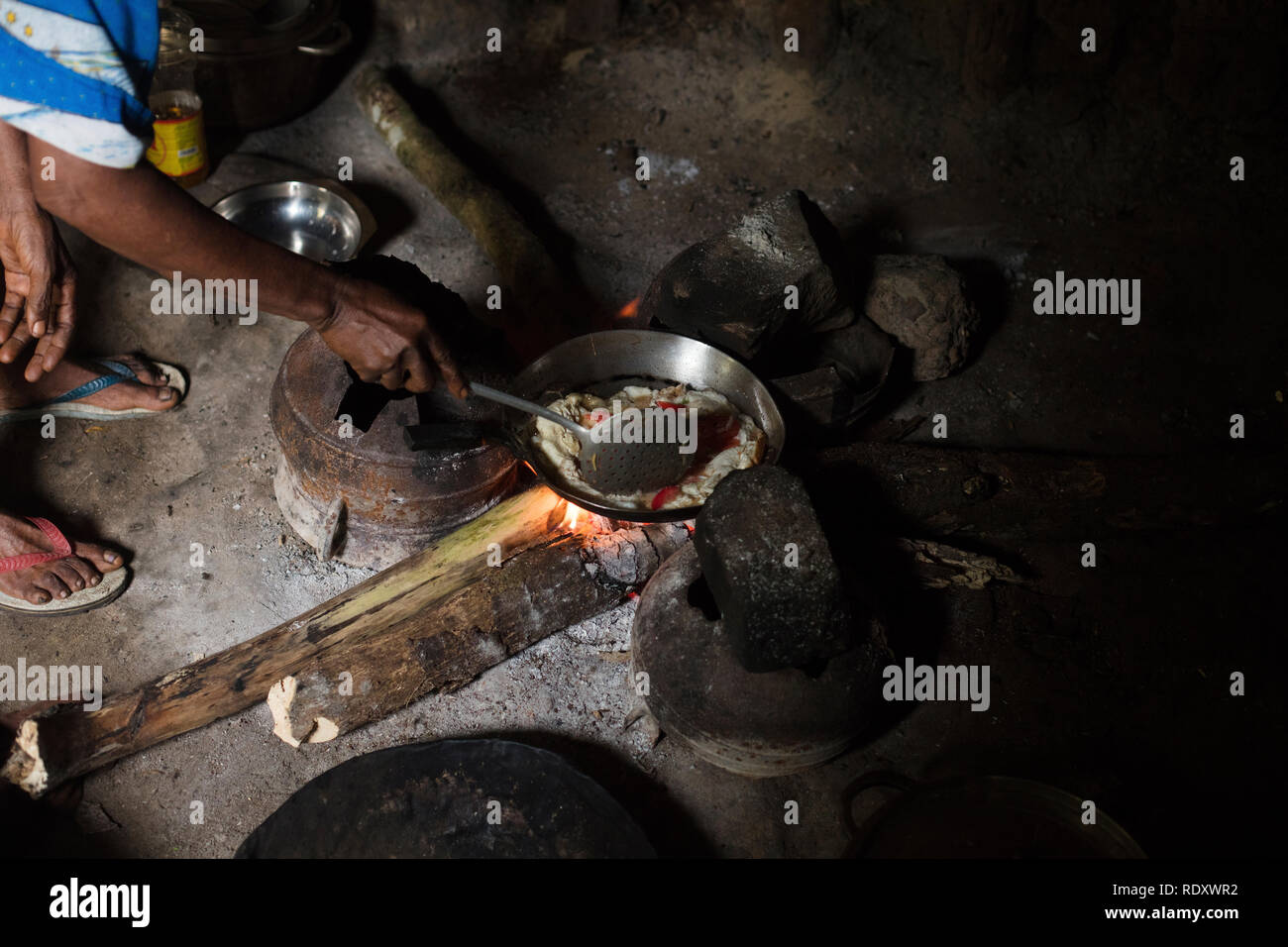 Une femme préparant une omelette sur le feu au Cameroun, l'Afrique. Banque D'Images