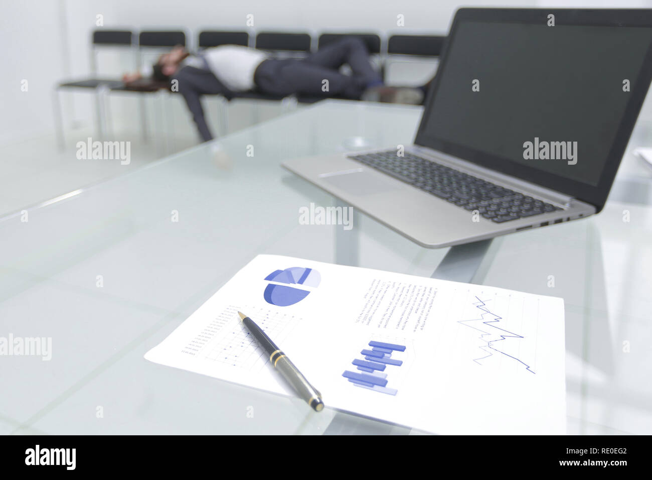 Image d'arrière-plan d'un ordinateur portable sur une table en verre dans un bureau vide Banque D'Images