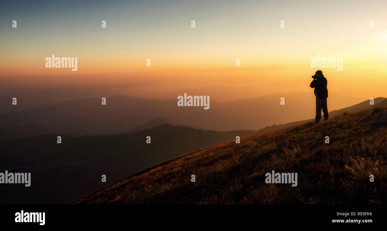 L'homme est de regarder le lever du soleil dans la montagne, de la Bulgarie, de l'heure d'été Banque D'Images