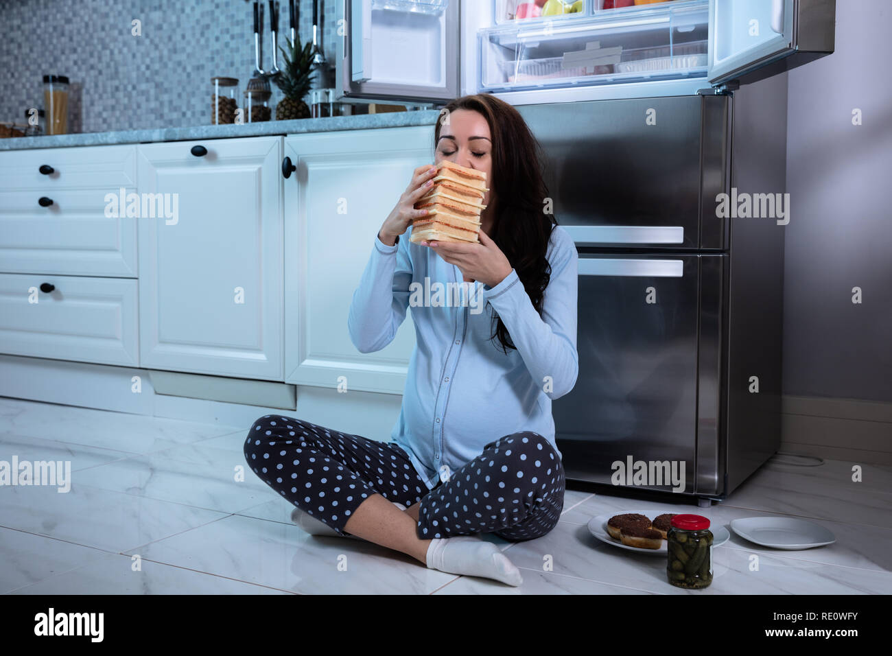 Young pregnant woman Eating sandwich dans la cuisine Banque D'Images