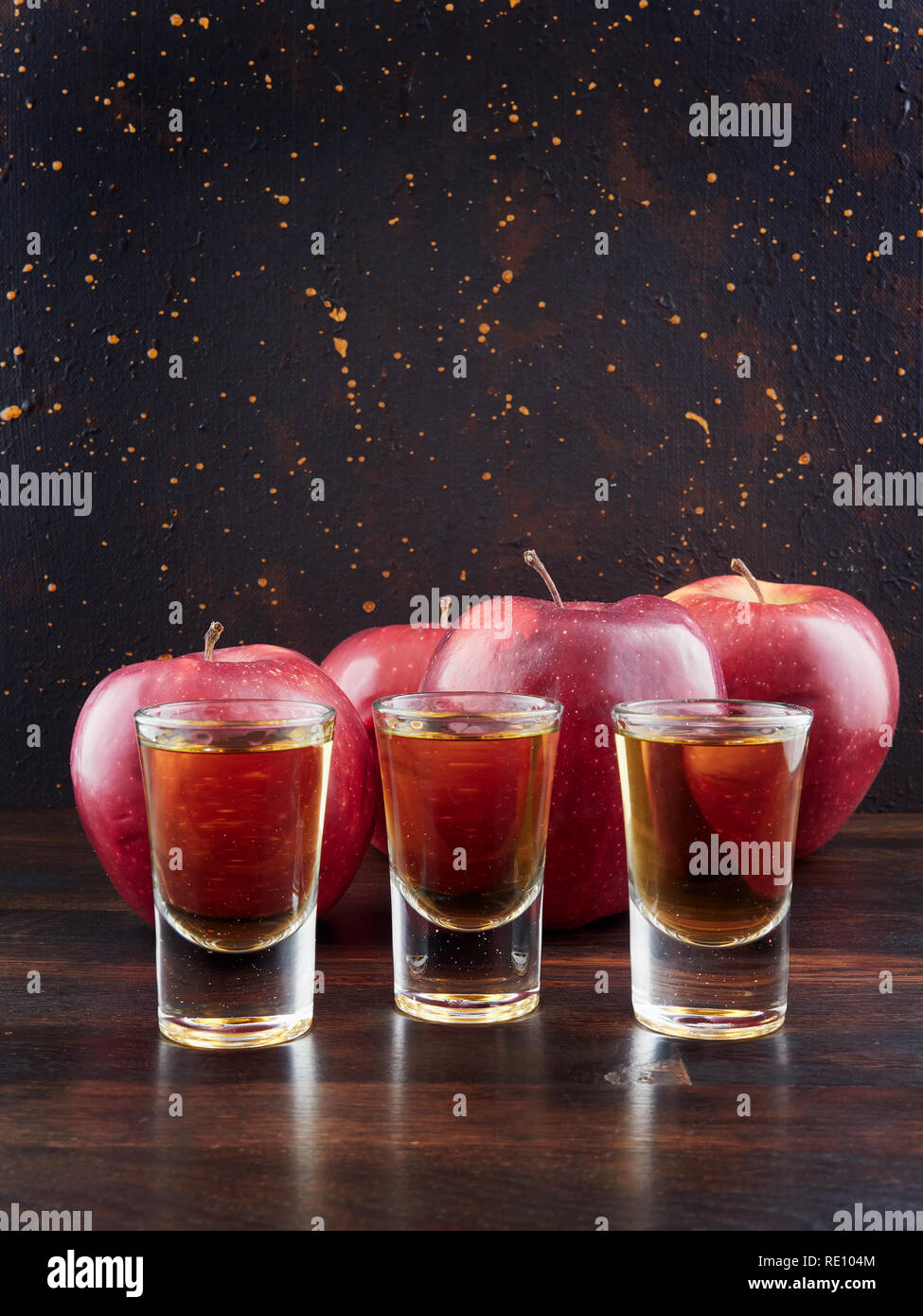 De pomme ou le Calvados et pommes rouges, sur une planche en bois foncé, avec un fond brun foncé Banque D'Images