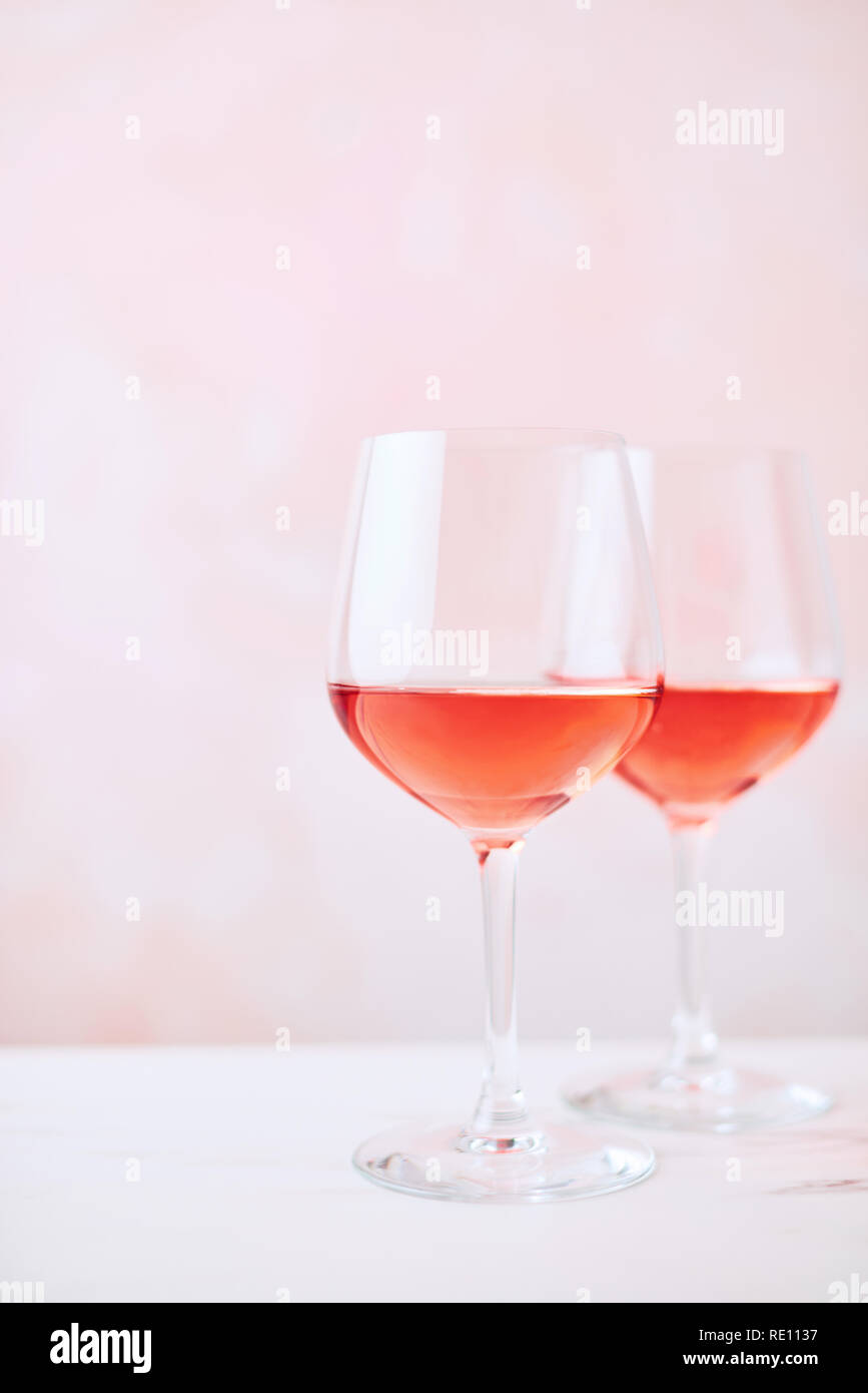 Boisson d'été. Verre de vin rose sur la table de marbre blanc sur fond rose avec copie espace pour le texte. Focus sélectif. Banque D'Images