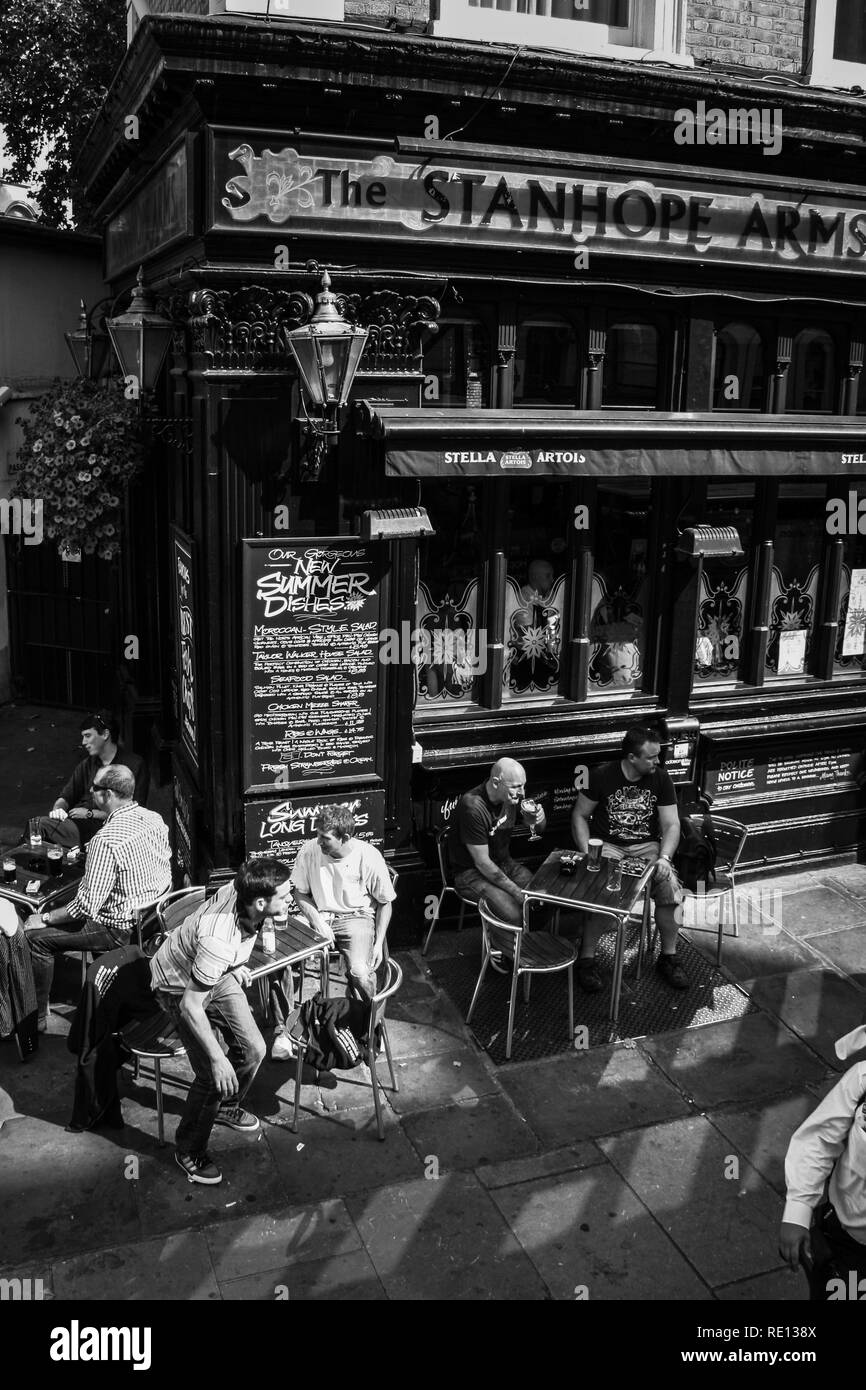 Photographie vintage noir et blanc de gens boire de la bière sur la rue des tables d'armes Stanhope pub à Londres, Royaume-Uni Banque D'Images