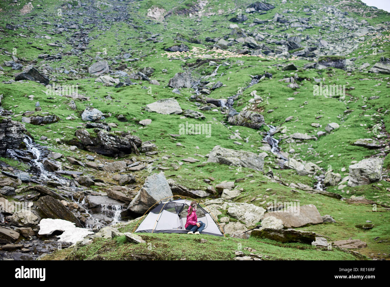 Fille dans une tente sur la pente rocheuse des montagnes de Fagaras. Concept de vie sain et actif. Carpates, Roumanie Banque D'Images