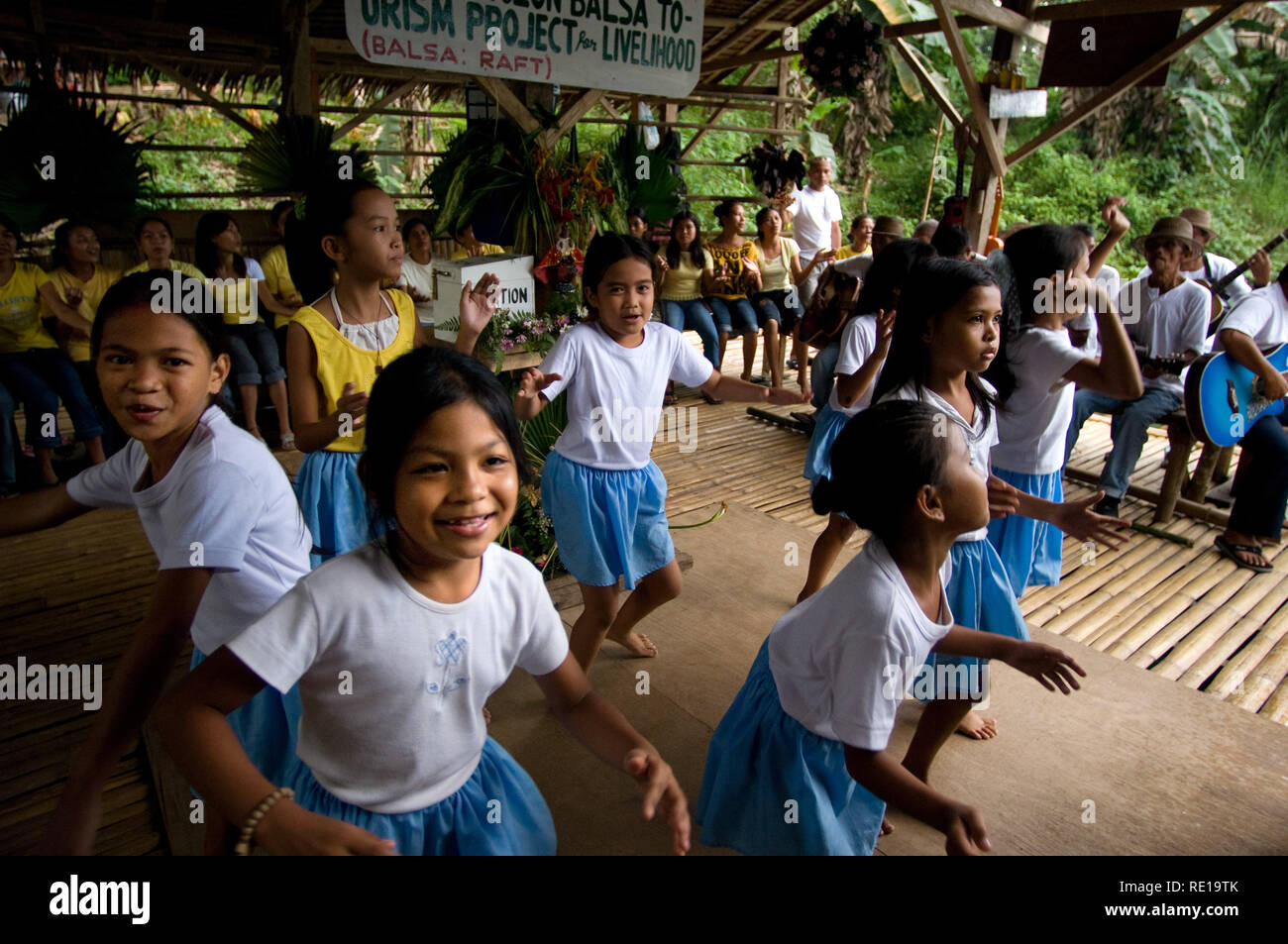 Certains enfants chantent et dansent sur les marges de la rivière Loboc quand les touristes arrivent alors qu'ils prendre un bateau. Bohol Philippines Loboc Banque D'Images
