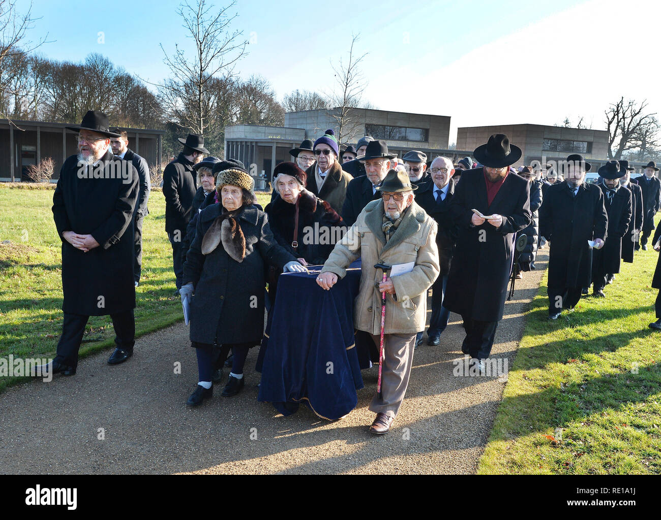 Un groupe de survivants de l'Holocauste un cercueil couvert de roue avec les restes de six Pas de Juifs assassinés à Auschwitz, d'être enterré à l'United Synagogue's nouveau cimetière de Bushey, Hertfordshire, après avoir été dans le Musée impérial de la guerre depuis des décennies. Banque D'Images