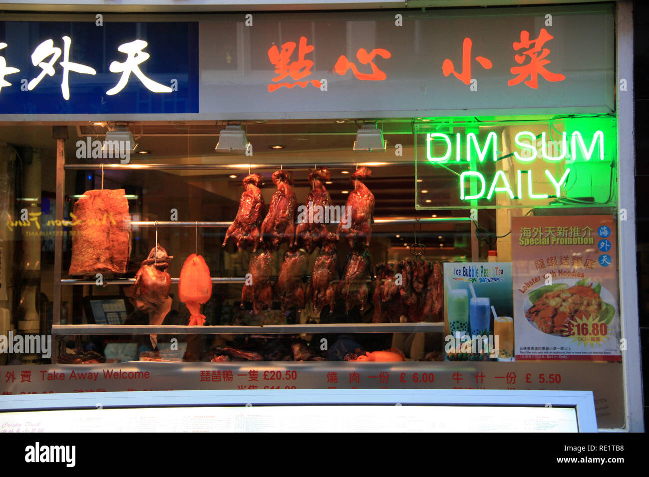 Canard rôti, un calmar géant et d'autres délicieux plats chinois suspendu dans la vitrine d'un magasin dans le quartier chinois de Londres, Royaume-Uni Banque D'Images