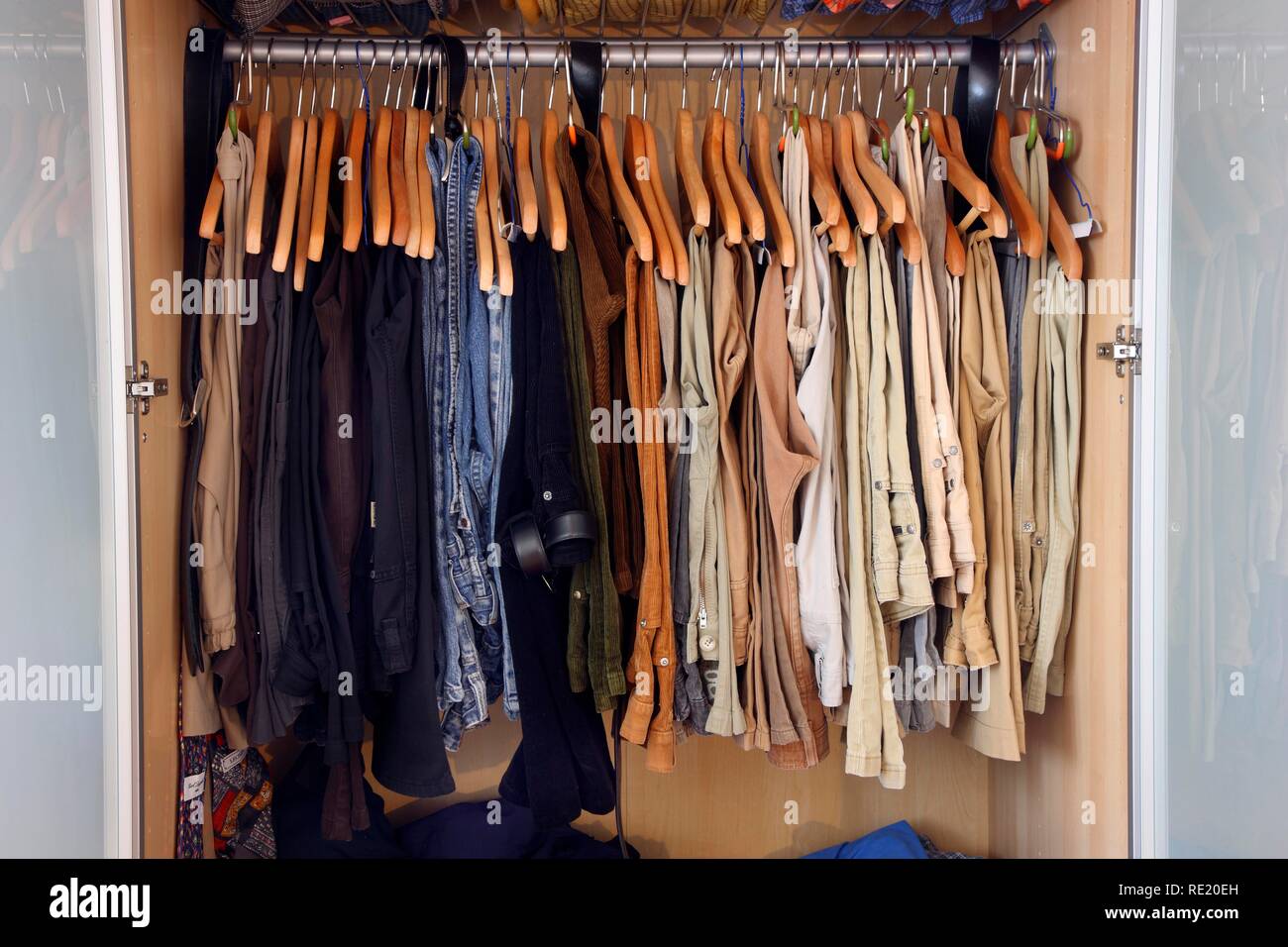L'armoire, des vêtements de toutes sortes la pendaison ou couché dans différents compartiments Banque D'Images