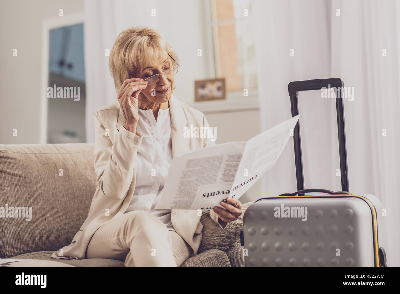 Attentif senior woman reading newspaper Banque D'Images