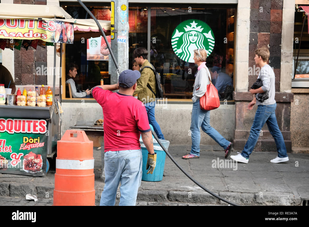 Un homme mexicain travaillant en face d'un café Starbucks store à Cholula, Puebla Mexique Banque D'Images