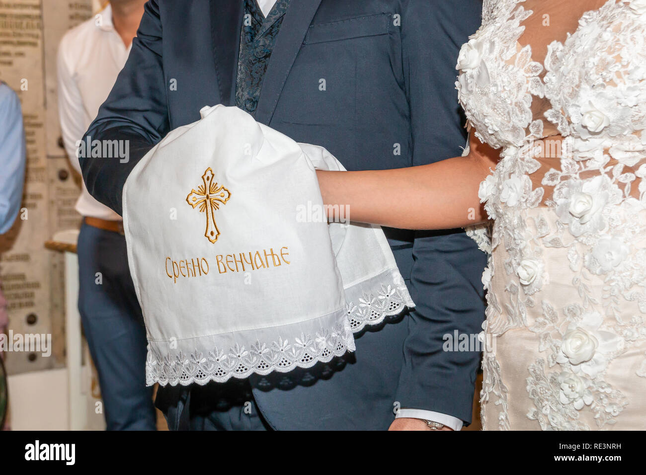 Mariage Mariage traditionnel dans l'Eglise orthodoxe. Mains de la mariée et le marié sont attachées avec une serviette brodée de mariage. «Срећно венчањ Inscription Banque D'Images