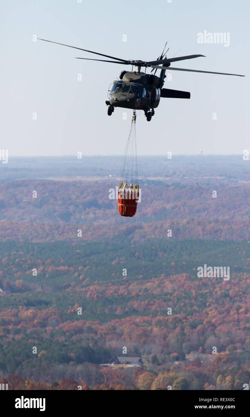 La Garde nationale de l'Alabama un UH-60 Black Hawk avec seau Bambi assemblée permet la distribution de l'eau de l'antenne, à la demande de l'Agence de gestion des urgences de l'Alabama, à l'appui des efforts de suppression des incendies de forêt dans le Comté de DeKalb, Illinois, 19 nov., 2016. Les soldats de la Garde nationale ont appuyé les efforts de lutte contre les incendies et contre les incendies multiples en Caroline du Nord, Caroline du Sud, Géorgie, Tennessee, Alabama et Mississippi. Banque D'Images