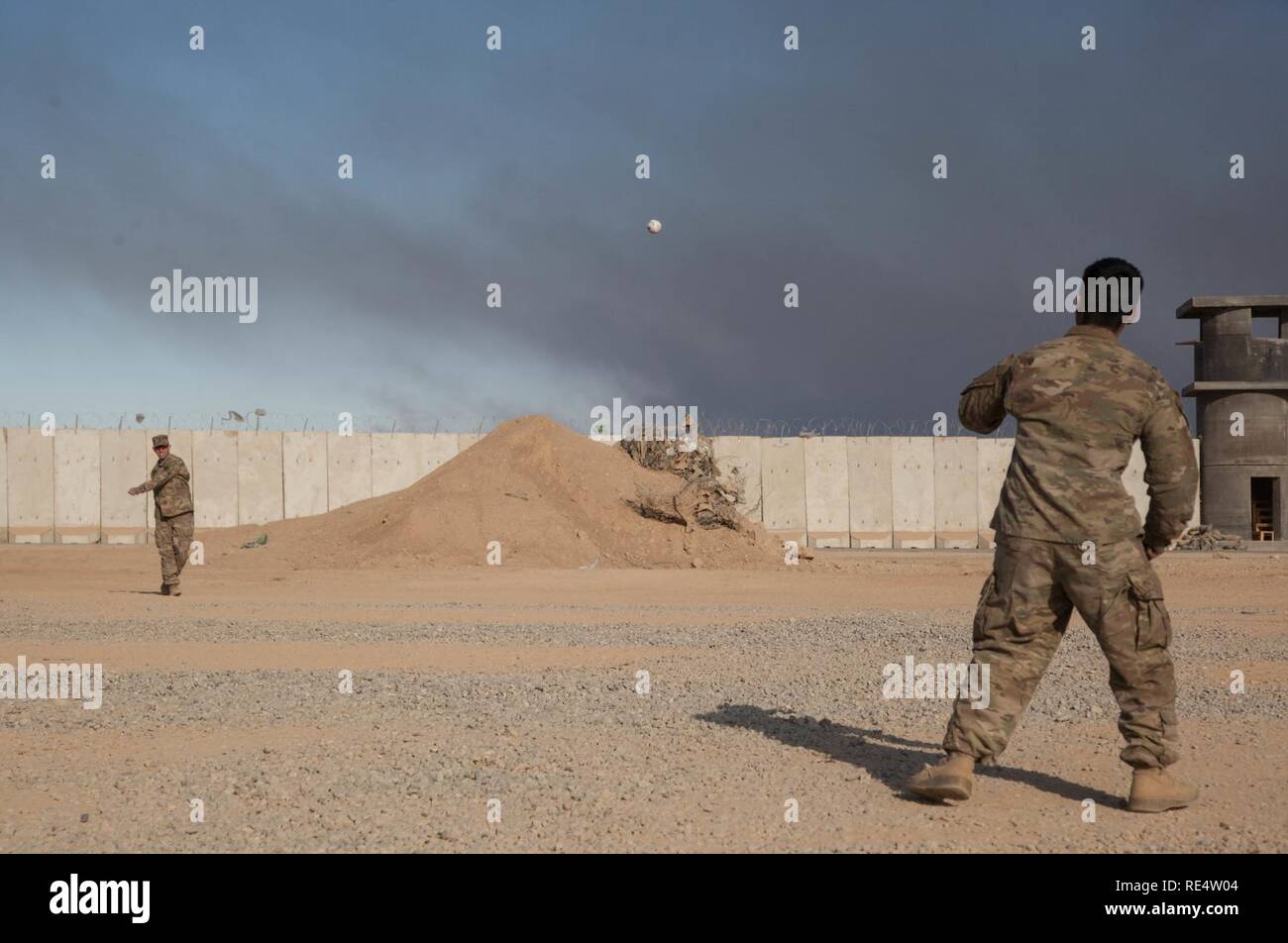 Les soldats de l'armée américaine, affecté à la 2e Peloton du 3e bataillon du 321e Batterie Baker Field Artillery Regiment 18e Brigade d'artillerie de lancer une balle de baseball en grève à Qayyarah entre missions Aérodrome à l'Ouest, de l'Iraq, le 23 novembre 2016. Une coalition de nations régionales et internationales se sont associées pour permettre aux forces iraquiennes pour contrer l'État islamique d'Irak et du Levant, rétablir les frontières de l'Iraq et de re-prendre du terrain perdu donc de restaurer la stabilité et la sécurité régionales. Banque D'Images