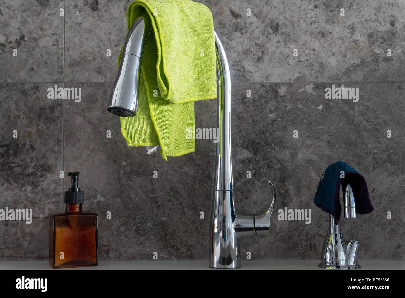 Pompe à savon, chrome robinet d'évier de cuisine, d'un robinet d'eau filtrée avec des chiffons en microfibre, en marbre gris et Dosseret carreau Banque D'Images