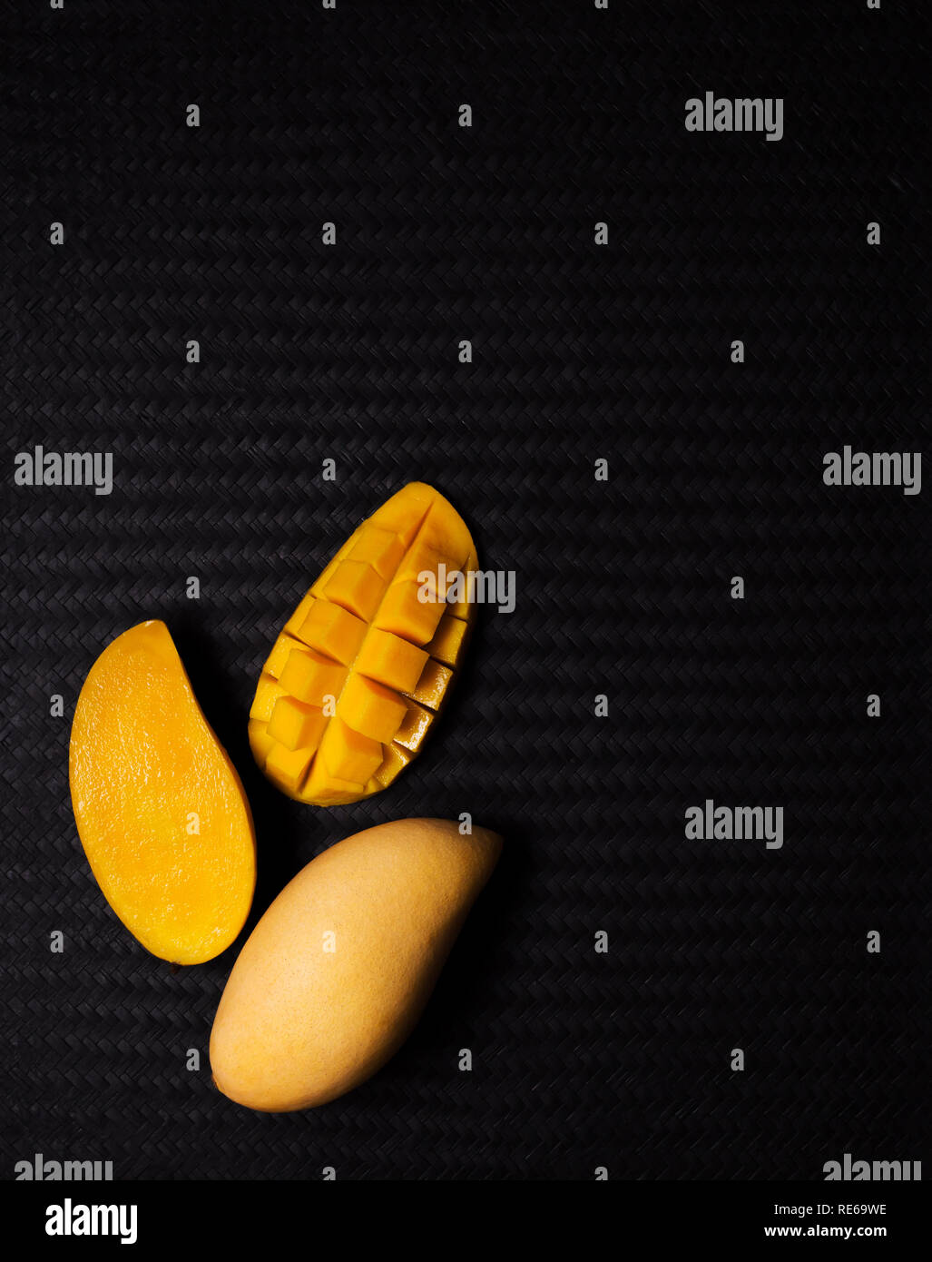 High angle view image d'appétissants fruits de mangue à la mangue en cubes et couper la moitié en armure noire texture background with copy space Banque D'Images