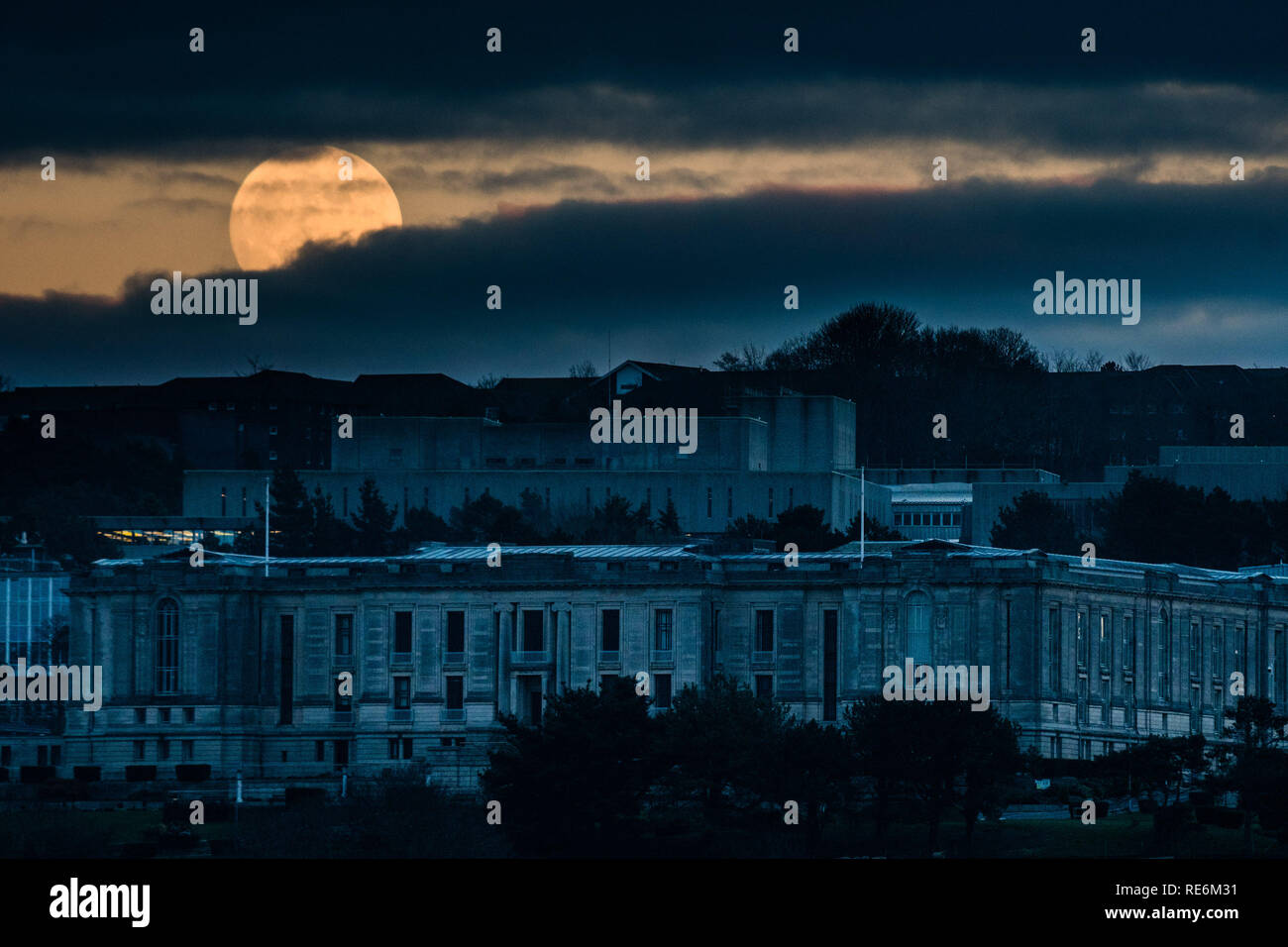 Aberystwyth, UK. 20 Jan 2019. La première pleine lune de 2019 a vu s'élève au-dessus de la Bibliothèque nationale du Pays de Galles à Aberystwyth au Pays de Galles au Royaume-Uni. Janvier La pleine lune est parfois appelé 'wolf moon', et est cette fois aussi une upermoon «', d'être un peu plus près de la terre et apparaissant plus grand et plus lumineux normal han pleines lunes. En quelques heures cette lune sera éclipsée par la terre et s'affiche à lueur rouge au petit matin ciel au-dessus de la UK Crédit photo Keith Morris / Alamy Live News Banque D'Images