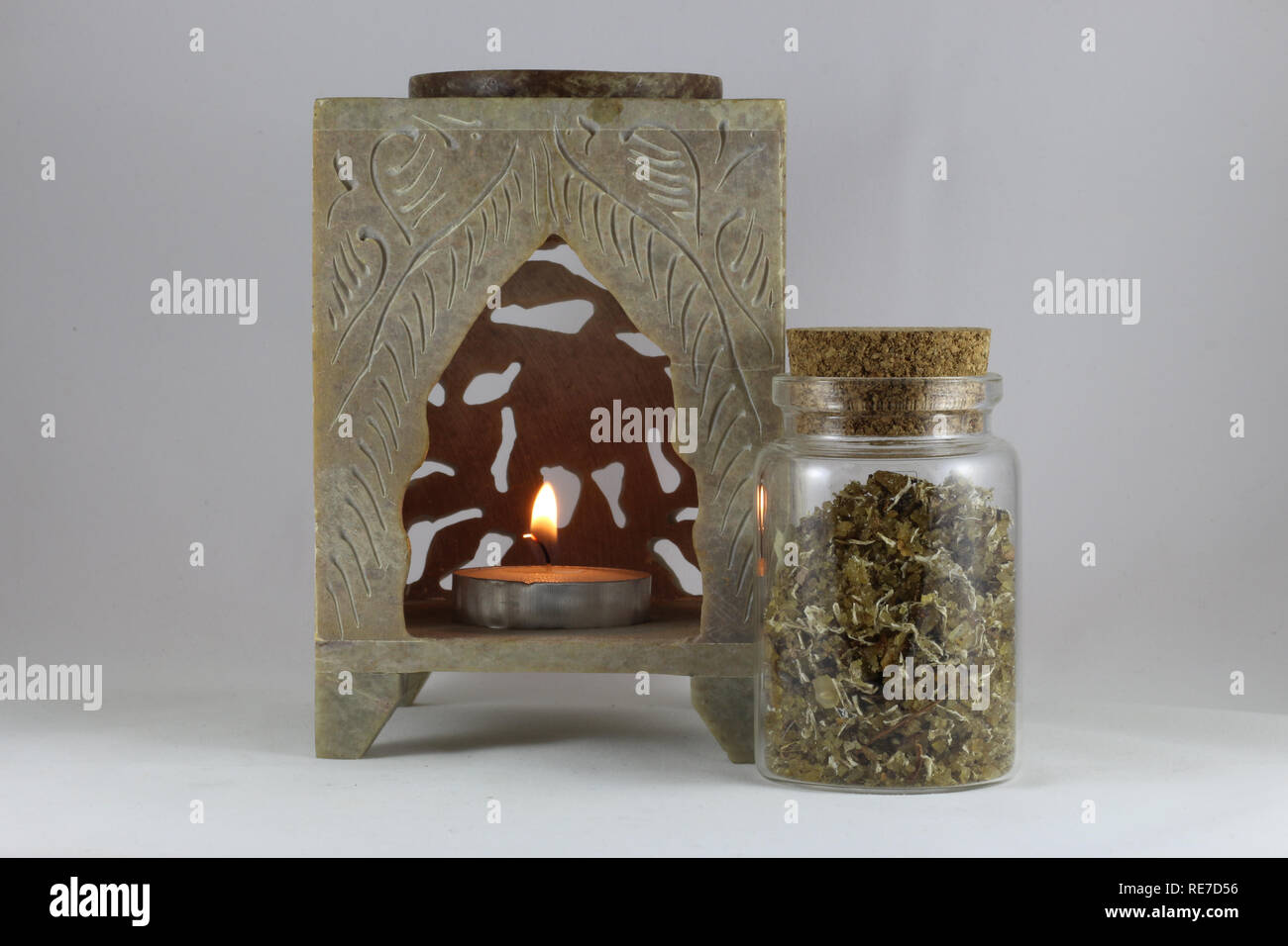 Encens Musc naturels aromatiques dans une bouteille et une bougie isolé sur fond blanc Banque D'Images
