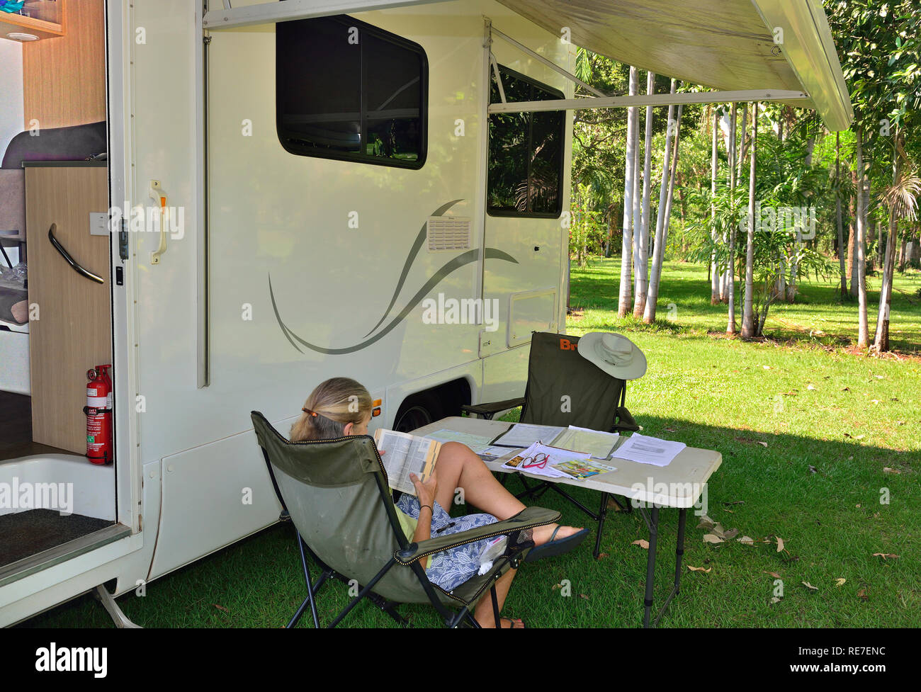 Tourisme assis à l'extérieur sous l'auvent du camping-car au parc de vacances Batchelor, Rum Jungle Road, Batchelor, territoire du Nord, Australie Banque D'Images
