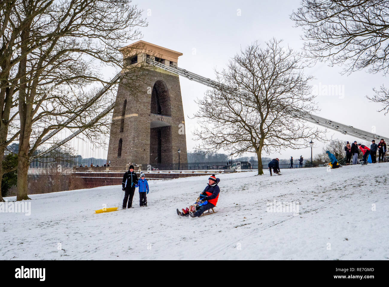 Les familles bénéficiant de l'occasion de neige de l'hiver faire du traîneau bas Sion Hill par le pont suspendu de Clifton Bristol UK Banque D'Images