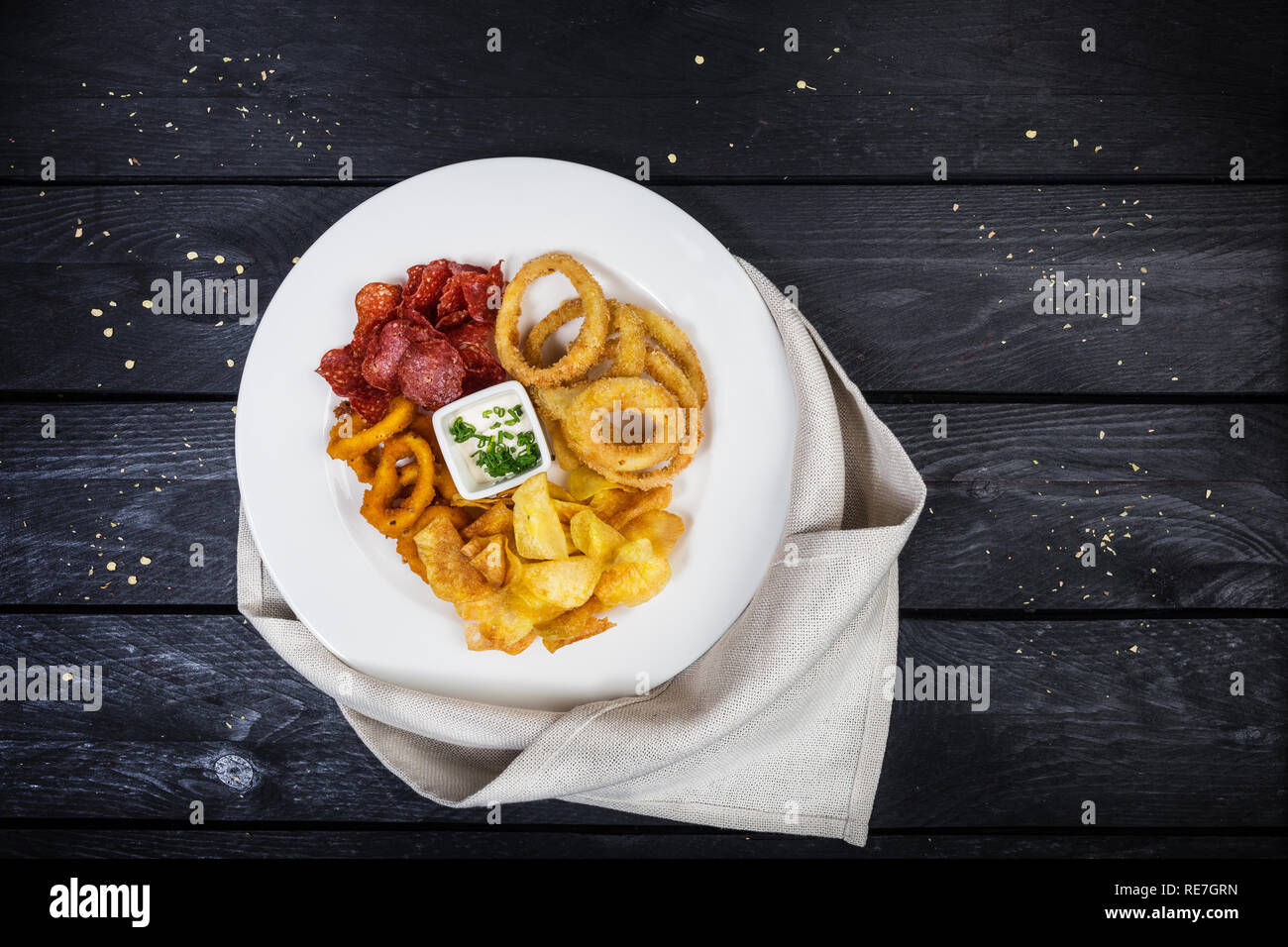 Anneaux de calmars, d'oignon, des croustilles de pommes de terre, salami puces avec sauce au fromage. Banque D'Images