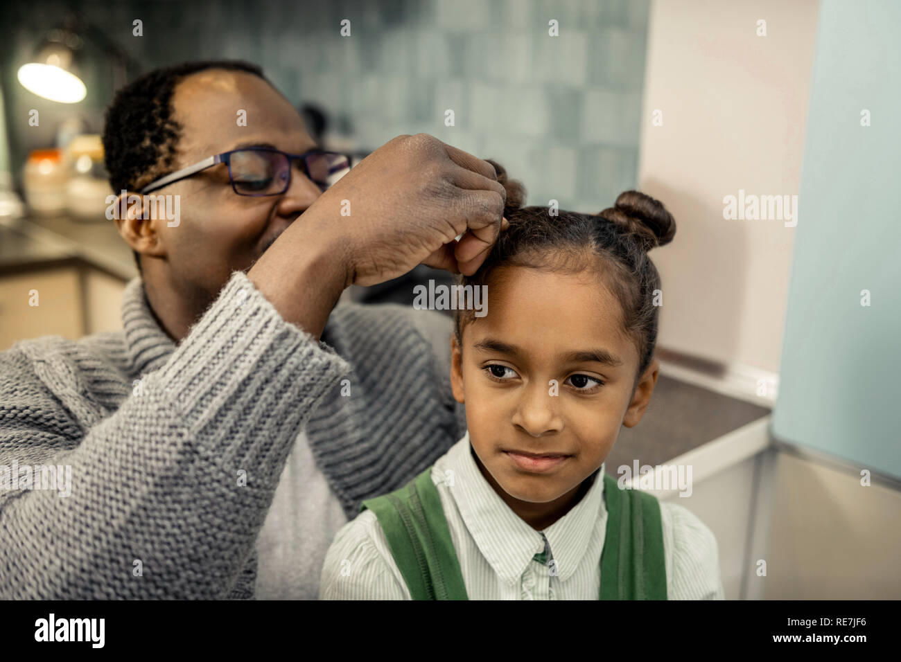 Père afro-américains faisant hairstyle pour sa jeune fille Banque D'Images