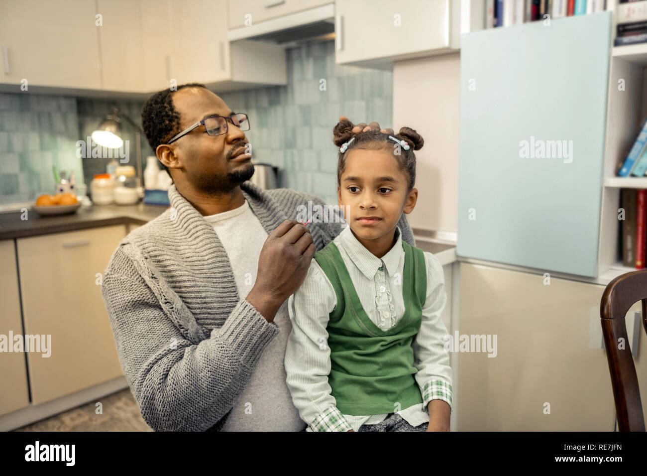 Père décisions hairstyle pour sa fille avant de la prendre à l'école Banque D'Images