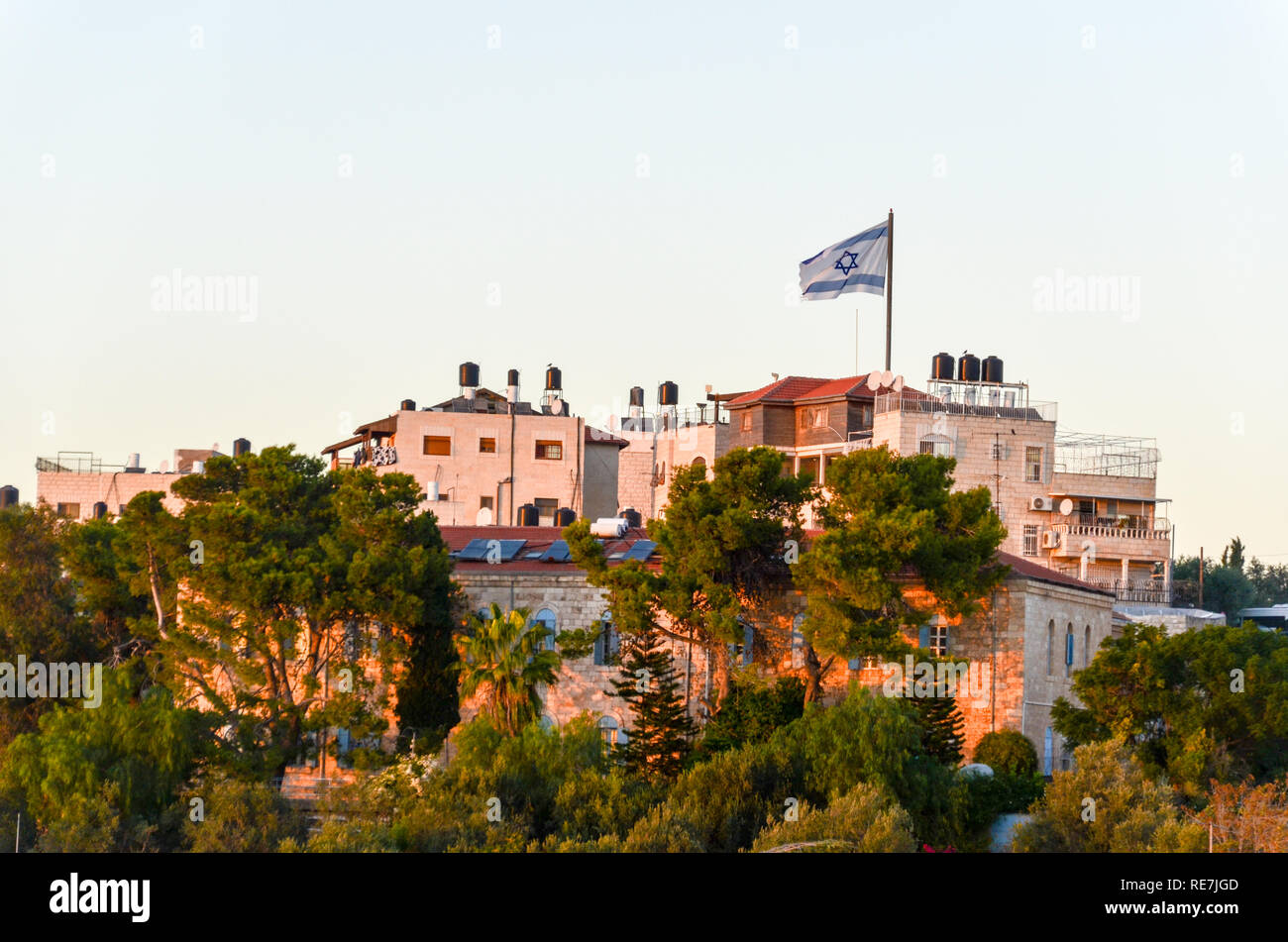 Grand drapeau israélien sur un quartier de Jérusalem Ouest, Cisjordanie, au coucher du soleil Banque D'Images