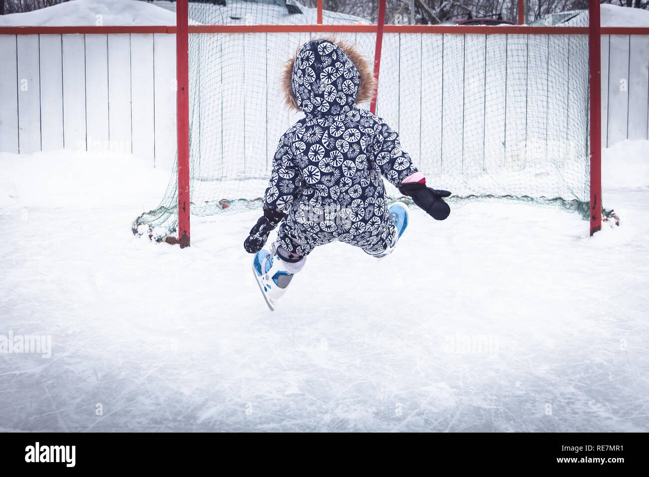 Tout-petit enfant d'apprentissage relevant du patinage sur glace patinoire surmonter les difficultés par le biais de blessures dans un parc de neige pendant les vacances d'hiver Banque D'Images