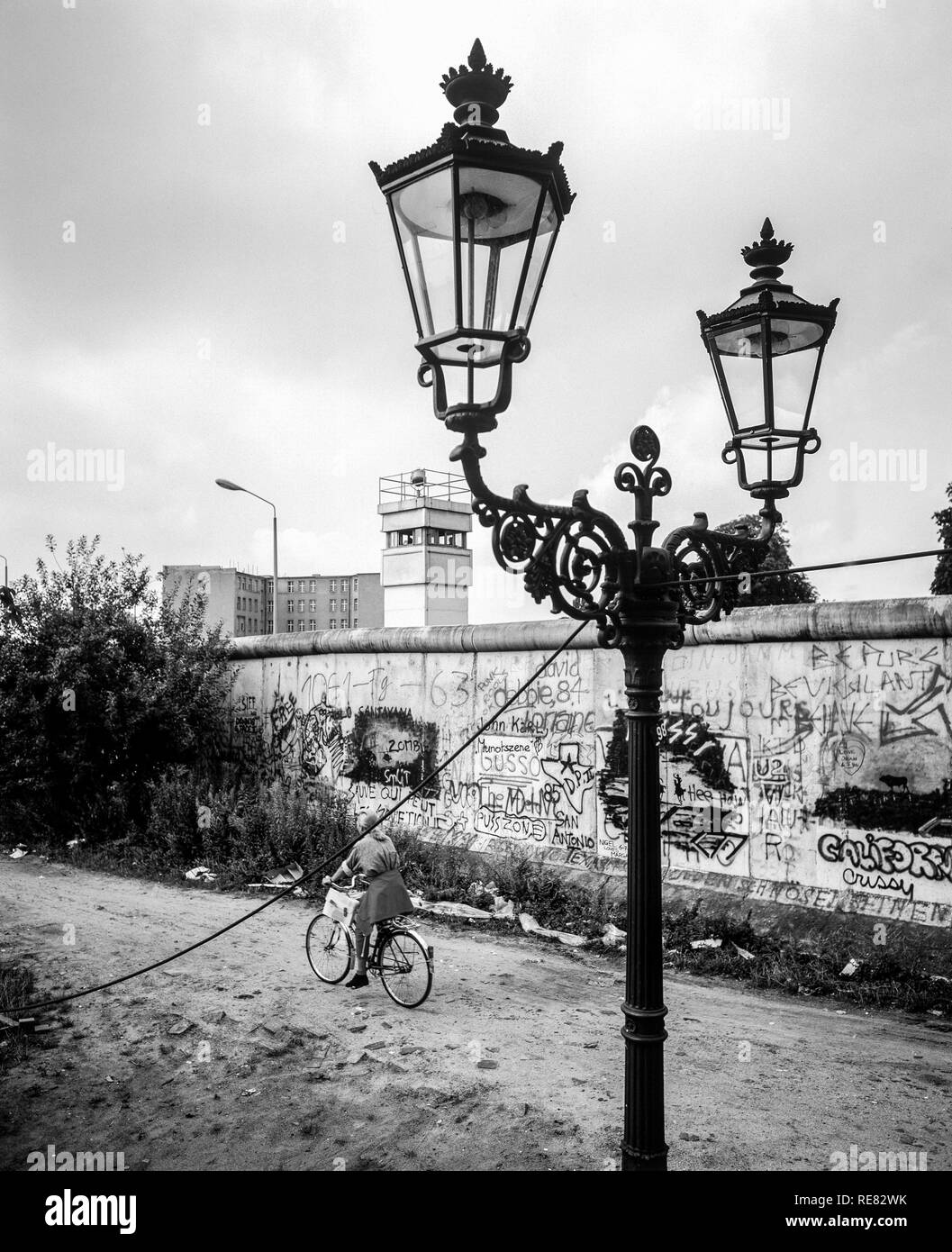 Août 1986 Mur de Berlin, graffitis, lampe de rue, des cyclistes, Berlin est watchtower, rue Zimmerstrasse, Kreuzberg, Berlin Ouest, l'Allemagne, l'Europe, Banque D'Images