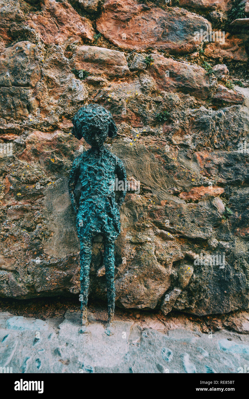 Statue de pierre d'une fille dans la rue d'un village Banque D'Images