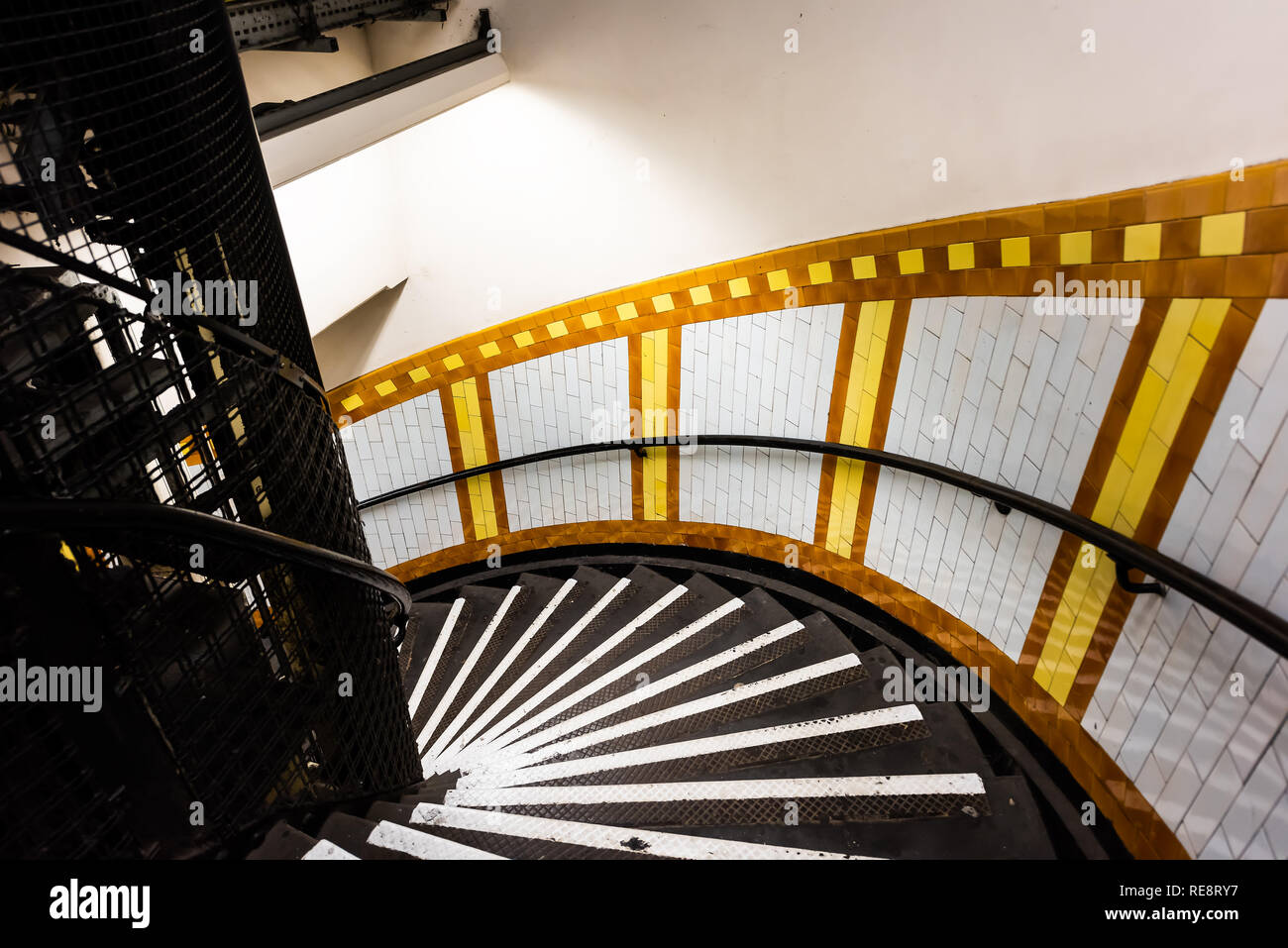 London, UK Covent Garden tube station spirale escalier souterrain Étapes vers le bas avec personne dans les escaliers architecture colorée jaune Banque D'Images