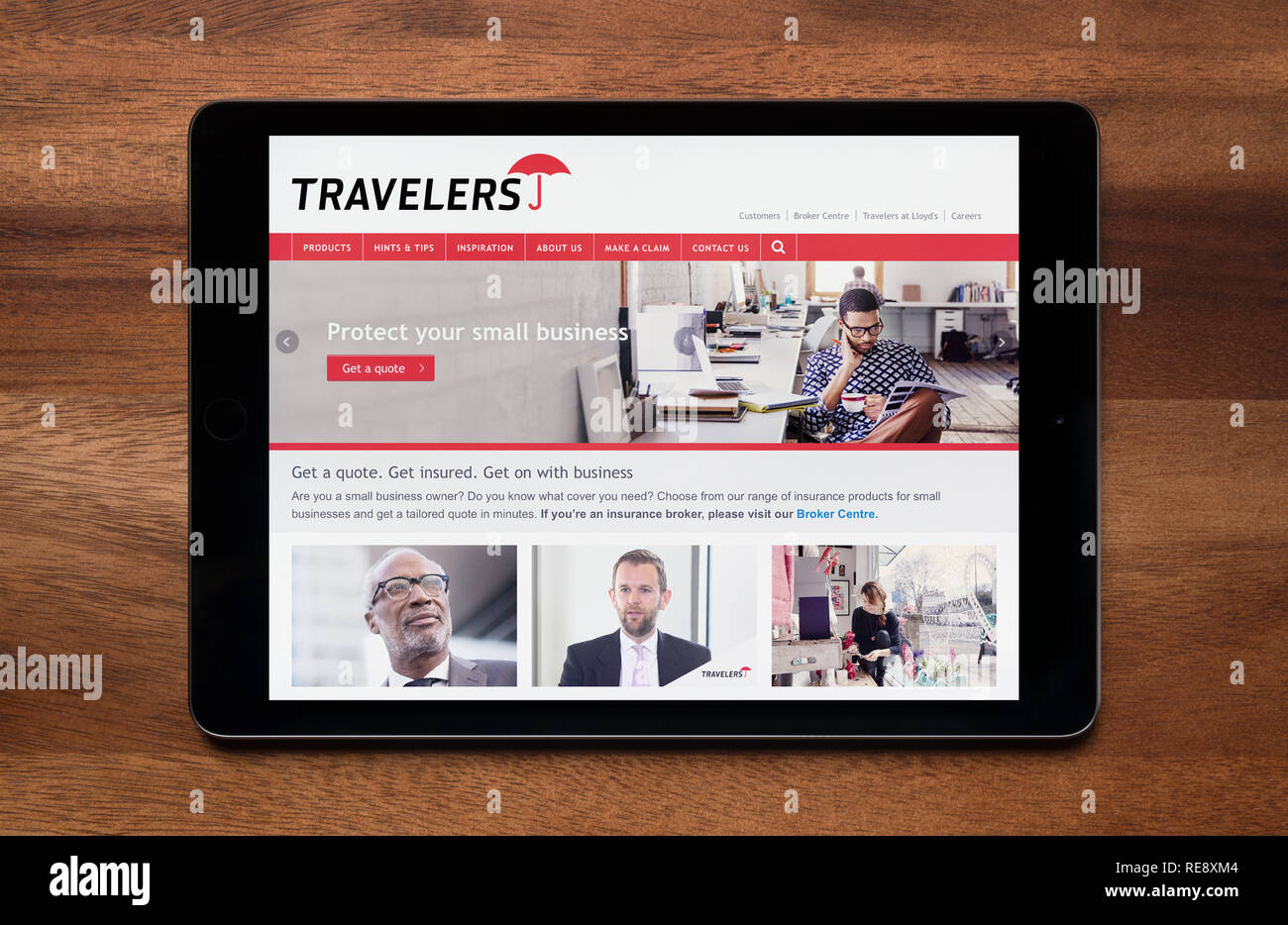 Le site web de l'assurance des voyageurs est vu sur un iPad tablet, qui repose sur une table en bois (usage éditorial uniquement). Banque D'Images