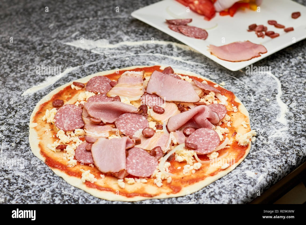 Différentes tranches de charcuterie de fromage sur la pâte. Jambons sur la pizza. Banque D'Images