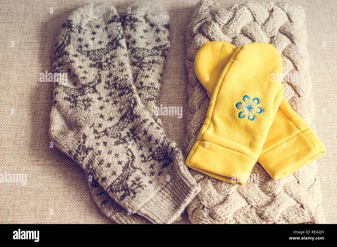 Une écharpe, des chaussettes chaudes avec des motifs et des points jaunes sont ce qu'il vous faut pour réchauffer par temps froid. Un blue snowflake est brodé sur les mitaines. Banque D'Images