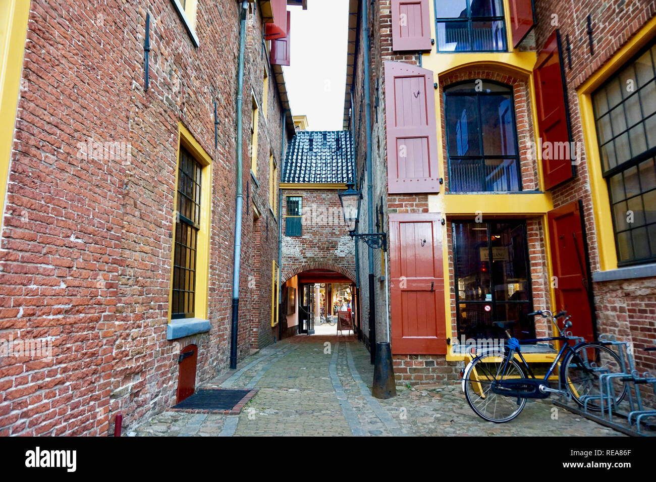 Groningen, Pays-Bas : restauré édifices médiévaux en Europe, peint en rouge vif et jaune garniture. Fenêtre traditionnelle (trappes) volets & co Banque D'Images