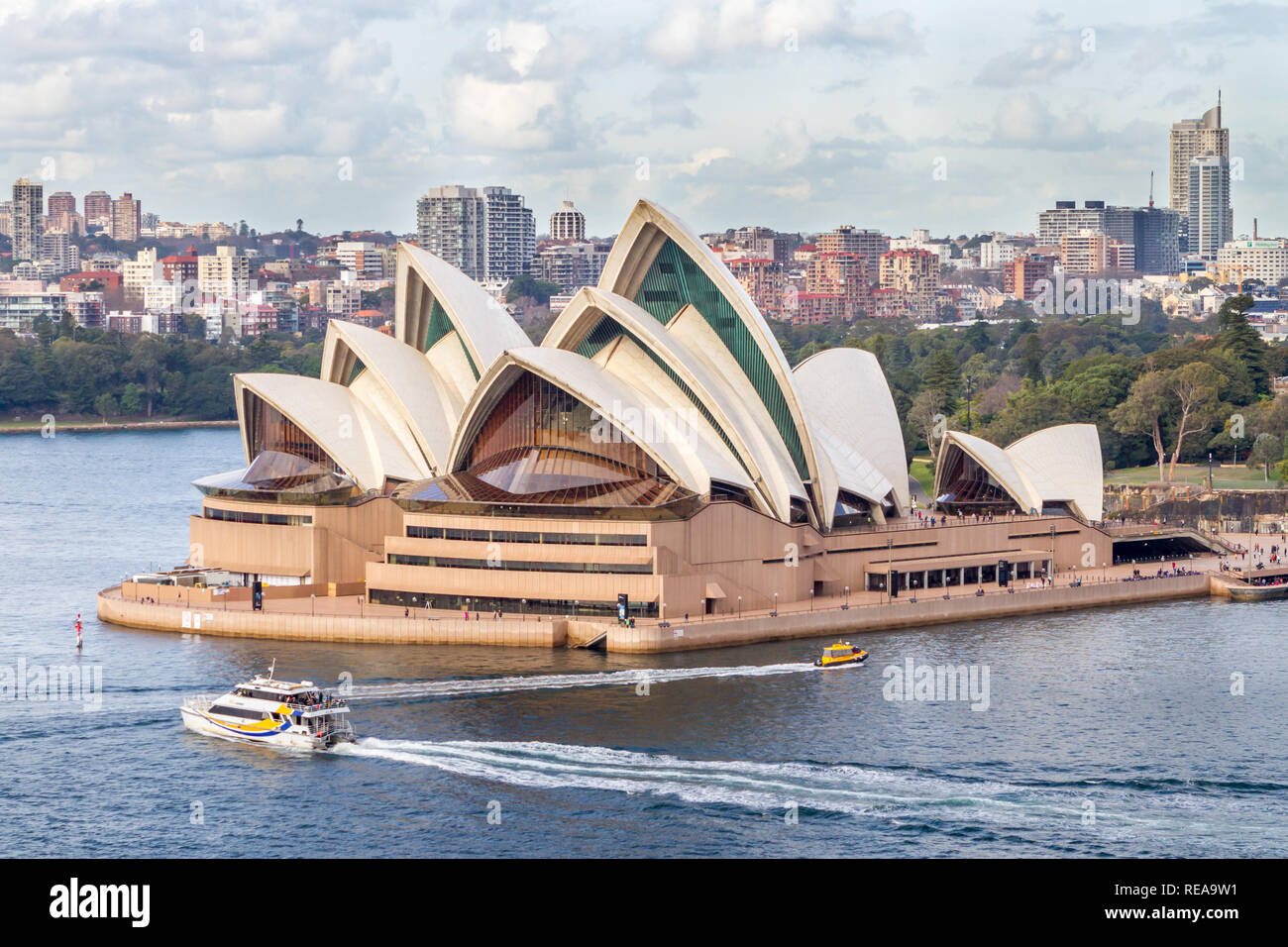 Opéra de Sydney - Harbour transports passent devant l'emblématique Opéra de Sydney avec le Sydney skyline derrière. Sydney, NSW, Australie Banque D'Images