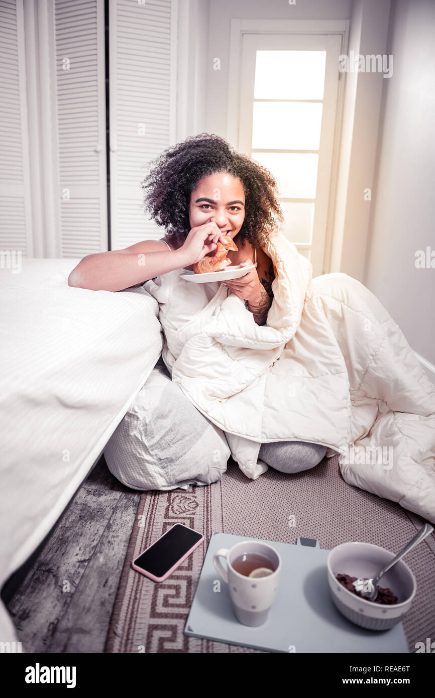 Coquettish bonne-femme à avoir petit-déjeuner français dans la chambre Banque D'Images