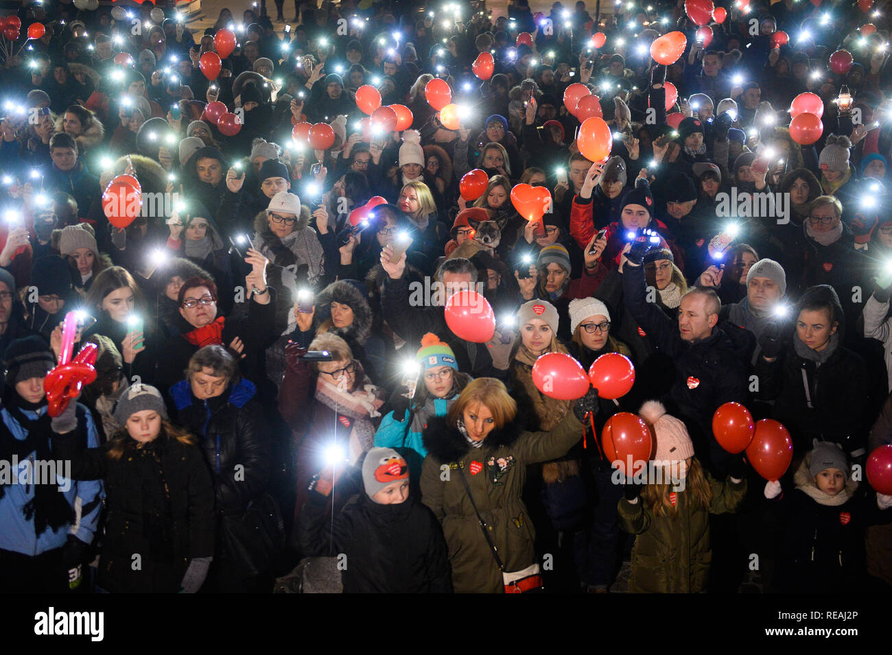 Les gens vu holding red balloons et clignotement des feux au cours d'une réunion publique pour soutenir la tête du grand orchestre de Charité de Noël, Jerzy Owsiak et rendre hommage au regretté maire de Gdansk, Pawel Adamowicz sur la place principale. Banque D'Images