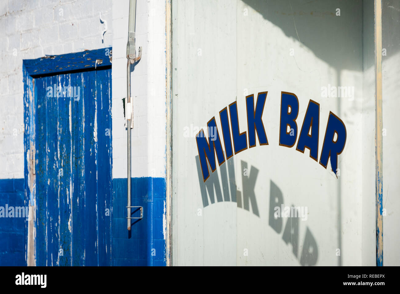 Old milk bar signe et porte bleue Banque D'Images