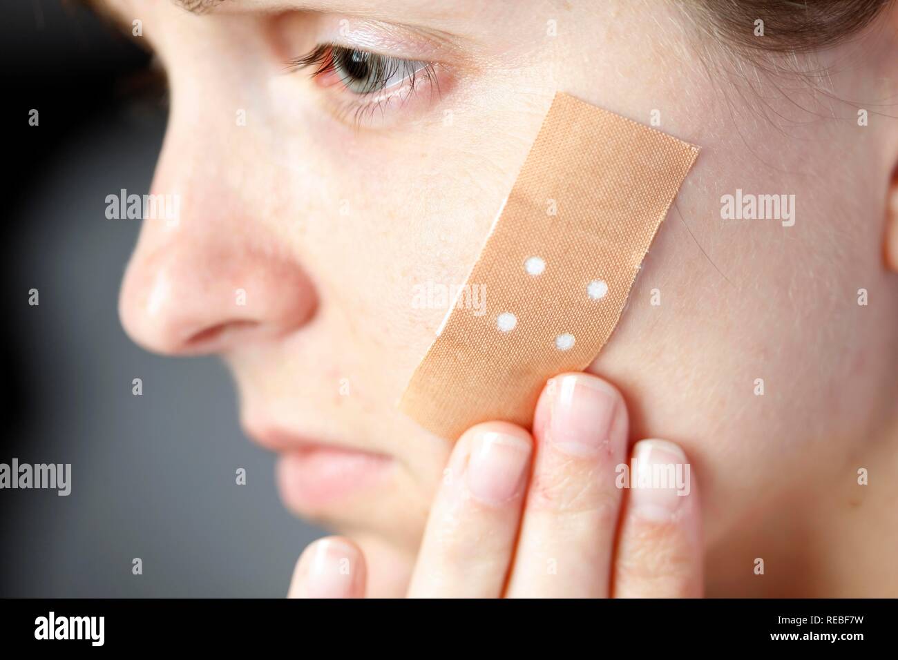 Femme avec un pansement adhésif sur son visage Photo Stock - Alamy