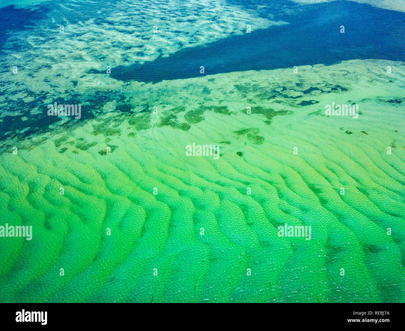 Les modèles et textures incroyables laissés par le sable avec de l'eau turquoise brillait au-dessus. Passage Pumicestone, Sunshine Coast, Queensland, Australie. Banque D'Images