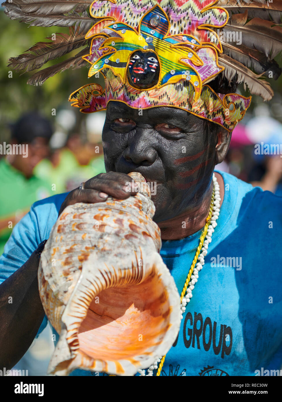 L'âge moyen des profils homme de se joindre à la Parade Ati-Atihan souffler dans une conque blanche le long de la plage sur l'île de Boracay, Aklan, Philippines. Banque D'Images