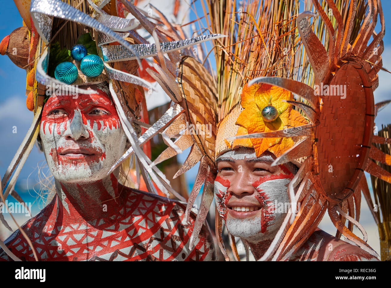 Deux jeunes hommes résident local se joint à l'Ati-Atihan défilé en costumes colorés conçu le long de la plage de sable blanc sur l'île de Boracay, Municipalité de Banque D'Images