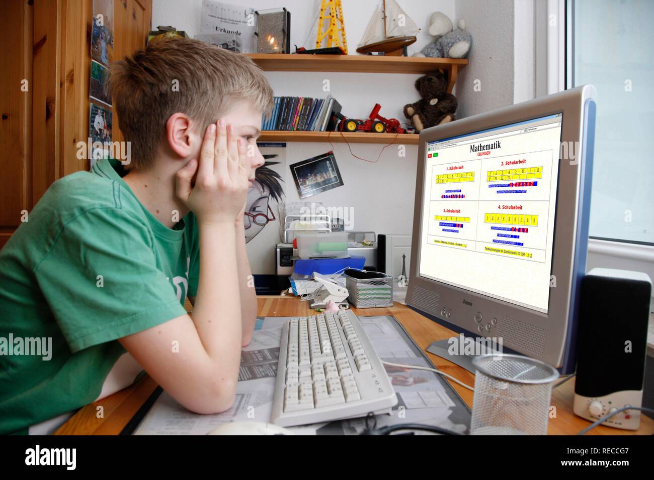 Garçon, 13, travaillant avec son ordinateur à domicile, programme d'apprentissage en mathématiques Banque D'Images
