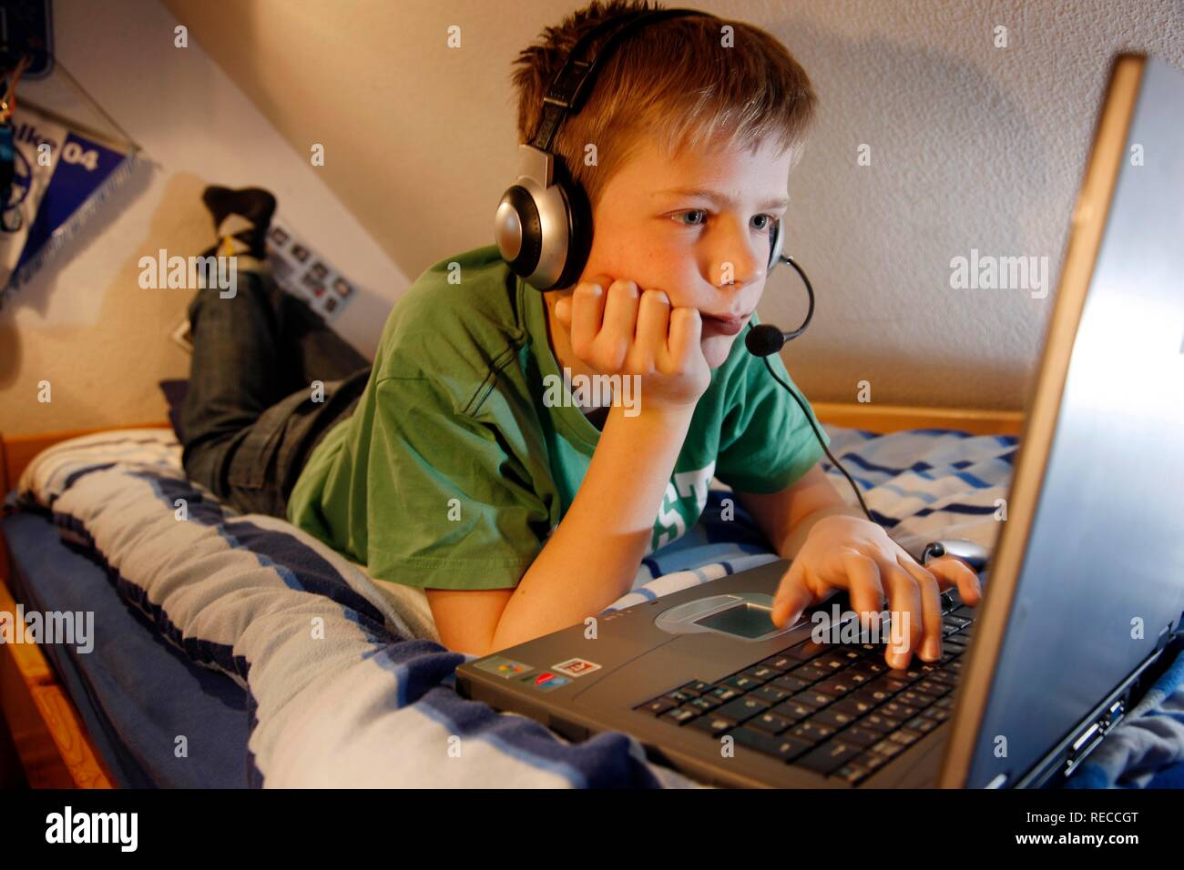 Garçon, 13, travaillant avec son ordinateur à la maison dans sa chambre  pendant qu'allongé sur son lit, la navigation sur Internet sur un forum et  chat Photo Stock - Alamy